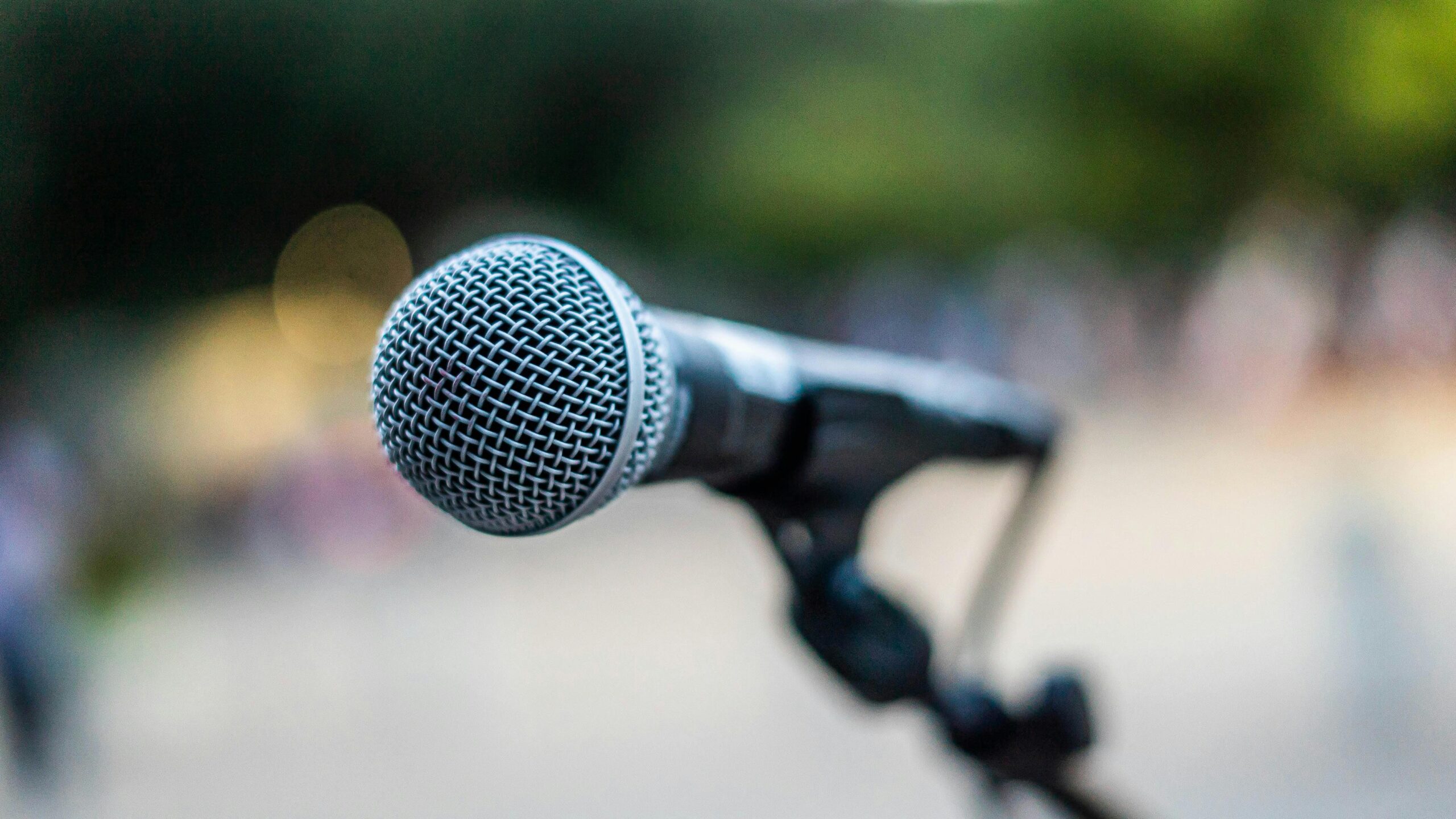 Microphone on stand representing voice, executive presence, and strategic facilitation — Bridging Momentum Waves speaking and facilitation services South Florida